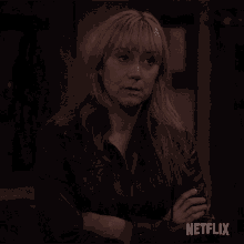 a woman with her arms crossed and a netflix logo in the corner