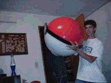 a man in a white shirt with the number 33 on it holds a large red ball