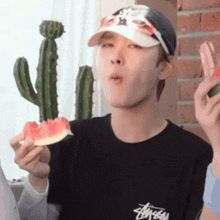 a man wearing a hat is eating a slice of watermelon