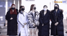 a group of women wearing face masks are standing next to each other in front of a newsen banner