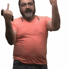 a man with glasses and a beard wearing an orange shirt giving the middle finger