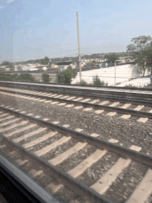 a train track with a white building in the distance
