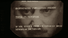 a man 's face is displayed on a screen that says " oldthinkers unbellyfeel ingsoc "
