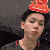 a man is wearing a sign on his head that says " เข้า ร่วม กับ ของขวัญ "