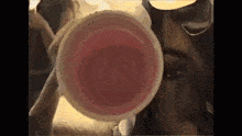a close up of a woman 's face with a cup in front of it .