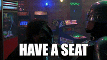 a man in an arcade with the words " have a seat " on the bottom