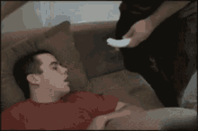 a man laying on a couch with his mouth open