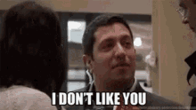 a man in a suit is talking to a woman and saying `` i don t like you '' .