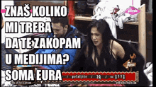 a man and a woman are sitting in a room with a sign that says soma eura on it