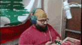 a man with a beard and headphones is playing a video game .