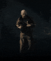 a man without a shirt is standing in a dark room