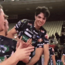 a man wearing a shirt that says mikasa is being congratulated by his teammates .