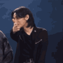 a man in a black jacket is giving a thumbs up .