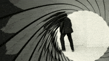 a man in a black suit is standing in a tunnel