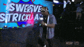 a man is dancing in front of a sign that says swerve strickland