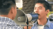 a man is shouting into a megaphone at another man