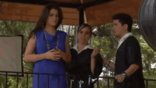 a woman in a blue dress is standing next to a man