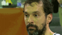 a man with a beard and a white shirt is sweating