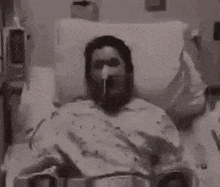 a man in a hospital bed with an oxygen mask on his face is being hit by a beam of light .