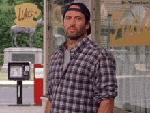 a man in a plaid shirt is standing in front of luke 's