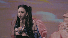 a woman with dreadlocks and blue nails is smiling and looking at the camera