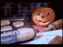 a pumpkin with a face carved into it is sitting next to a bottle of cadbury creme .