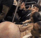 a group of people are sitting on a bus and one of them is wearing an at & t shirt
