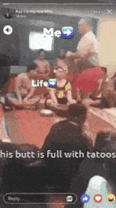 a group of people are sitting on the floor with a caption that says his butt is full with tattoos .