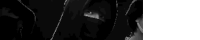 a black and white photo of a person 's face with a hood on .