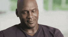 a bald man wearing a purple shirt with the word espn on the back
