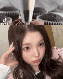 a girl is making a cupcake with a piping nozzle and a tik tok logo