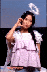 a woman with angel wings and a halo on her head is wearing a purple top