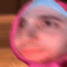 a blurry picture of a person 's face with a pink and blue background
