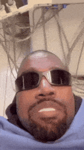 a man with a beard is wearing sunglasses and a blue shirt