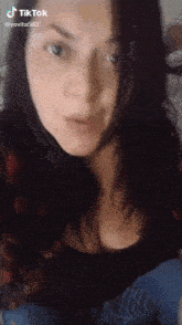 a close up of a woman 's face with tiktok written on the bottom