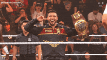 a wrestler wearing a jacket that says page is holding a championship belt