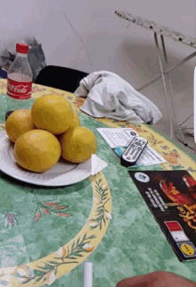 a bottle of coca cola sits on a table with a plate of lemons