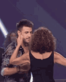 a man and a woman are dancing together on a stage .