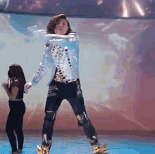 a man in a blue jacket is dancing with a girl