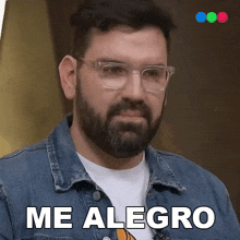 a man with a beard wearing glasses and a blue jacket says me alegro