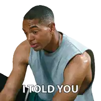 a man in a tank top says i told you while sitting on an exercise bike