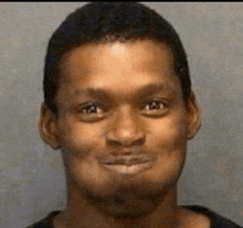 a man with a beard is smiling for the camera in a mug shot .