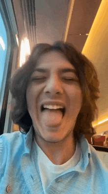 a man with long hair sticking his tongue out