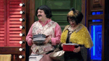 a man and a woman are holding pots and pans