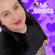 a woman is standing in front of purple hearts and the word la costia is above her