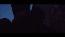a person in a hooded jacket is standing in the dark