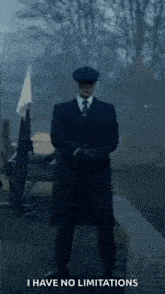 a man in a suit and tie is standing in front of a river holding a gun and a flag .