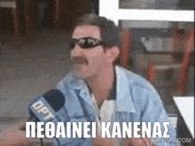 a man wearing sunglasses and a mustache is talking into a microphone with the word opt on it