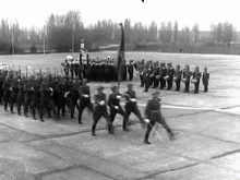 a black and white photo of a marching band and soldiers