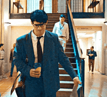 a man in a suit and tie is walking up stairs
